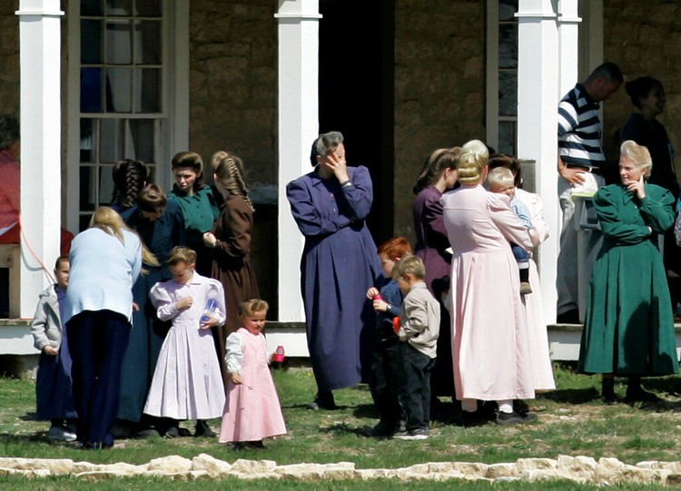 The Fundamentalist Church of Jesus Christ of Latter Day Saints Adult members of The Fundamentalist Church of Jesus Christ of Latter-day Saints gather as children play with bottles of bubble water on the grounds of their temporary housing at Fort Concho National Historic Landmark in San Angelo, Texas, Apr. 7, 2008. (AP Photo/Tony Gutierrez)