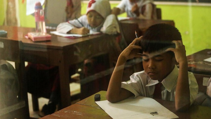 183 Siswa Ikut UAS Sebelum Terusir dari SDN Pocin 1 Guru pengawas memberikan kertas ujian Penilaian Akhir Semester (PAS) di SDN Pondok Cina 1, Depok, Jawa Barat, Selasa (6/12/2022). Pekan ujian Penilaian Akhir Semester (PAS) yang berlangsung sampai 9 Desember tersebut menjadi pekan terakhir para siswa berkegiatan belajar mengajar sebelum direlokasi ke SDN Pocin 3 dan SDN Pocin 5 dikarenakan lahan sekolah itu akan dijadikan masjid. ANTARA FOTO/Asprilla Dwi Adha/rwa.