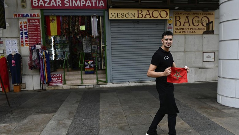 A man poses with a Moroccan flag in Spains north African enclave of Ceuta, Monday, Dec. 5, 2022. The World Cup knockout game between Spain and Morocco on Tuesday will bring millions of fans on both sides of the Strait of Gibraltar together around screens in bars and living rooms to see which country will keep alive its dream of soccer glory. But loyalties be blurred in Spains north African enclave of Ceuta where identities often mix in unpredictable ways. (AP Photo/Antonio Sempere)