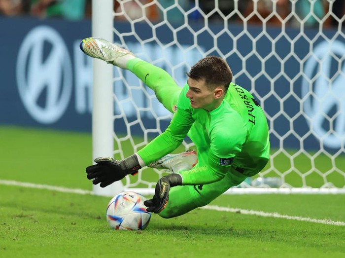 AL WAKRAH, QATAR - DECEMBER 05: Dominik Livakovic of Croatia makes one of three penalty saves during the shoot out to become the team's hero and help securte the passage ot the next round following the FIFA World Cup Qatar 2022 Round of 16 match between Japan and Croatia at Al Janoub Stadium on December 05, 2022 in Al Wakrah, Qatar. (Photo by Youssef Loulidi/Fantasista/Getty Images)