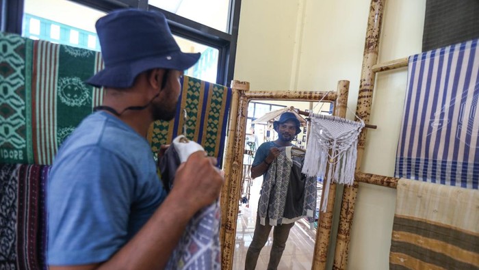 Pengunjung mencoba pakaian dari kain tenun Tidore di Rumah Tenun Puta Dino Kayangan, Kota Tidore Kepulauan, Maluku Utara.