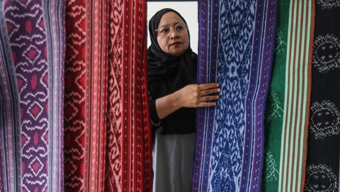 KAIN TENUN TIDORE YANG PERNAH HILANG Pengunjung mencoba pakaian dari kain tenun Tidore di Rumah Tenun Puta Dino Kayangan, Kota Tidore Kepulauan, Maluku Utara.