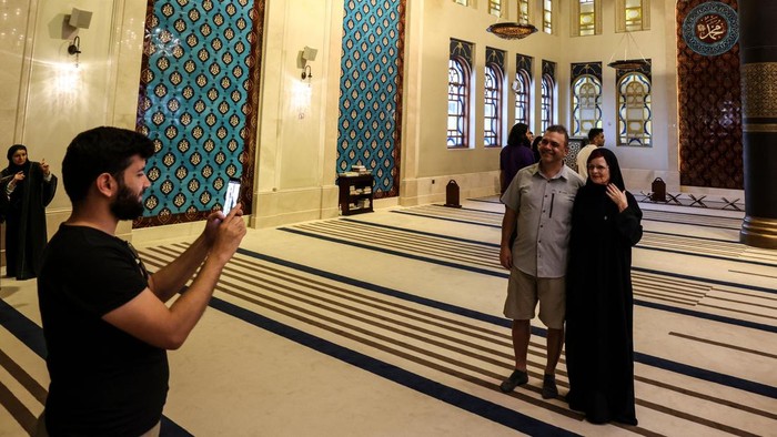Football fans and local residents visit Doha's Blue Mosque, during the Qatar 2022 World Cup football tournament, on November 29, 2022. - Qatar has taken advantage of the World Cup to reach out to the hundreds of thousands of visiting fans to change minds about Islam or even make conversions. The Gulf emirate is the first Muslim nation to stage a World Cup and its gas riches have endowed it with an array of grand mosques to pique the curiosity of visitors. (Photo by MAHMUD HAMS / AFP) (Photo by MAHMUD HAMS/AFP via Getty Images)