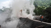 Ekskavator mengeruk material vulkanik Semeru yang menimbun jalanan di Desa Kajar Kuning.