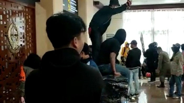 Momen Satpol PP hendak mengamankan bola berwarna merah yang dimainkan oleh sejumlah Suporter di lobi utama Kantor Gubernur Sulsel.