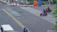 Dua pengendara motor ini sama-sama melanggar marka. Bahkan salah satunya sampai berhenti di zebra cross. Ingat, zebra cross buat pejalan kaki ya, bukan untuk area kendaraan berhenti. (Foto: Deny Prastyo Utomo/detikJatim)
