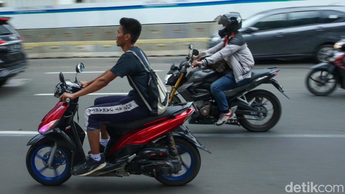 Pemotor Tanpa Helm Cuek Melintas di Jalan Protokol Jakarta Pemotor melintas di jalan M.H Thamrin, Jakarta, Selasa (6/12/2022). Para pemotor ini nampak berani melintas tanpa menggunakan helm.