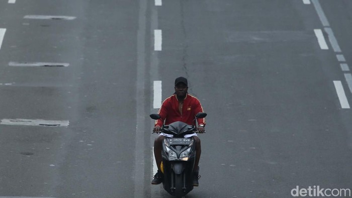 Pemotor melintas di jalan M.H Thamrin, Jakarta, Selasa (6/12/2022). Para pemotor ini nampak berani melintas tanpa menggunakan helm.