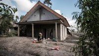 Penempakan rumah warga yang terisolasi akibat erupsi Semeru. AFP via Getty Images/JUNI KRISWANTO.