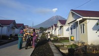 Warga penyintas bencana awan panas guguran (APG) Gunung Semeru berbelanja sayur di depan hunian tetap berlatar Gunung Semeru di Desa Sumbermujur, Candipuro, Lumajang, Jawa Timur, Selasa (6/12/2022).