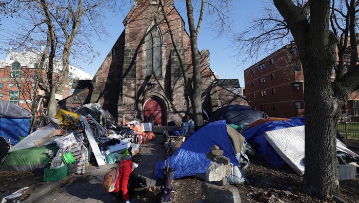 Tenda-tenda Tunawisma Penuhi Halaman Gereja di Kanada TORONTO, ON - DECEMBER 4 - Volunteers and residents help tidy an encampment outside The Church of Saint Stephen-in-the-Fields in Toronto, December 4, 2022. The Church of Saint Stephen-in-the-Fields is trying to clear out as much clutter as possible from its surrounding encampments, facing notice from the city that it'll clear out everything that isn't a tent from the perimeter on Monday, and a separate notice that the entire encampment on the west side needs to be gone by Thursday. (Steve Russell/Toronto Star via Getty Images)