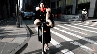 Seorang wanita terlihat mengendarai skuter di area pusat perbelanjaan di Manhattan.