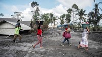 Warga saat mengevakuasi barang-barang yang bisa diselamatkan JUNI KRISWANTO/AFP via Getty Images.