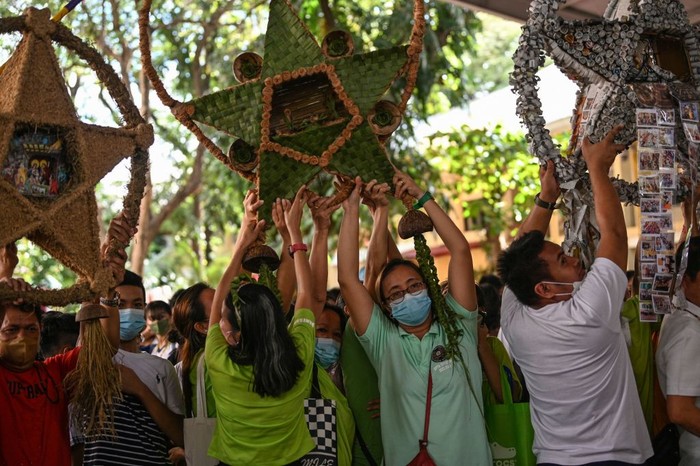 Teachers, students and parents hold Christmas lanterns made from recycled materials during a campaign for a toxic-free and waste-free Christmas celebration at an elementary school in Quezon City on December 7, 2022. (Photo by Ted ALJIBE / AFP) (Photo by TED ALJIBE/AFP via Getty Images)
