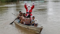 Sinterklas di Brasil ini malah numpang di perahu warga untuk memberikan hadiah kepada anak-anak. (Michel Dantas/AFP/Getty Images)  