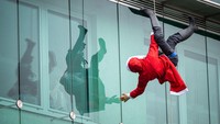 Sinterklas ini melakukan segala cara untuk menghibur anak-anak di rumah sakit, salah satunya dengan gelantungan di jendela. (Jure Makovec/AFP/Getty Images)