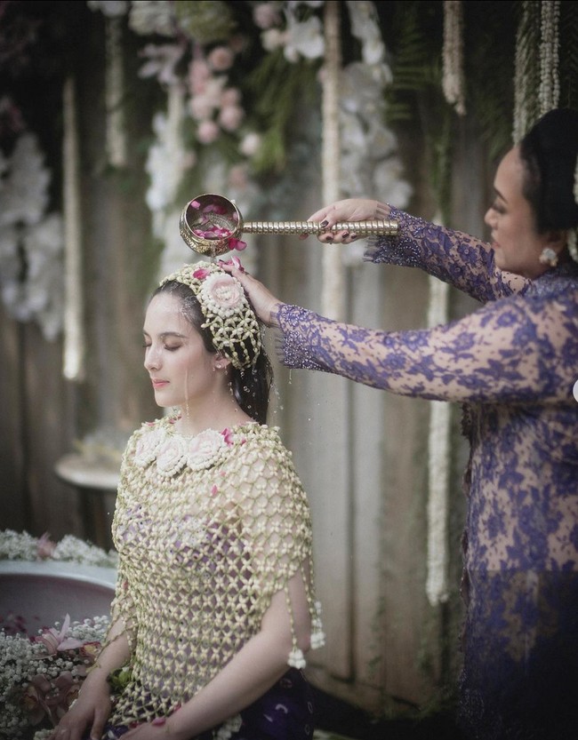 Saat siraman, aktris 27 tahun ini memakai roncean melati dan kain jumputan. Sementara wajahnya dipulas riasan nude bernuansa natural. Foto: Instagram/@iluminen @thebridestory