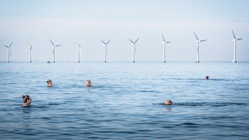 Pemenang kategori Adapting for Tomorrow diraih Simone Tramonte. Lokasi: Copenhagen, Denmark.“Pemandangan ladang angin lepas pantai Middelgrunden dari Amager Strand, pantai yang sangat populer di Kopenhagen. Lanskap ladang angin berpadu sempurna dengan pantai yang sangat populer ini di mana penduduk setempat pergi berjemur atau bermain olahraga air. Ladang angin dikembangkan dengan keterlibatan yang kuat dari masyarakat lokal dalam tahap perencanaan dan sebagai investor. 14,4% dari konsumsi listrik Denmark disediakan oleh angin. Lebih dari 150.000 keluarga Denmark adalah anggota koperasi turbin angin seperti ini.”Foto: Environmental Photographer of the Year