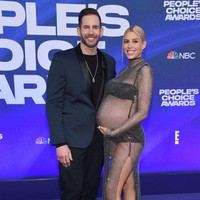 Heather Rae Young memamerkan perut buncitnya dengan gaya seksi. Tampil bersama sang suami Tarek El Moussa, aktris sekaligus model ini mengenakan gaun transparan fish net keluaran David Koma. Foto: Getty Images