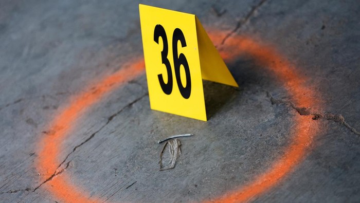 Signs are placed around circled objects during investigation, following a blast at a district police station, that according to authorities was a suspected suicide bombing, in Bandung, West Java province, Indonesia, December 7, 2022.  REUTERS/Willy Kurniawan