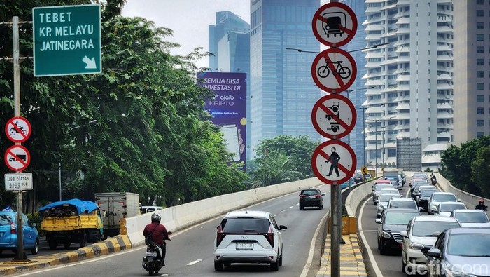 Minim e-TLE, Pemotor Makin Berani Terobos JLNT Para pemotor memacu kendaraan di jalan layang non tol Tanah Abang-Tebet, Jakarta, Rabu (7/12/2022). Jalan layang tersebut terlatang bagi kendaraan roda dua untuk melintas. Namun, para pemotor berani menerobos karena belum ada fasilitas tilang elektronik (ETLE) di ruas jalan tersebut. Satu pembonceng terlihat tidak mengenakan helm.