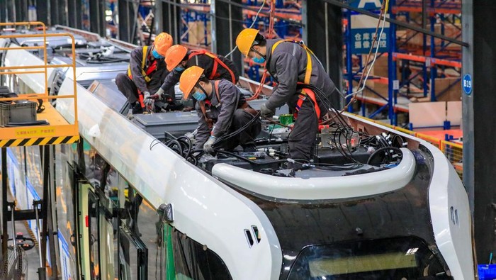 Pernah Lihat Kereta Pintar? Nih Penampakan Pabriknya YIBIN, CHINA - DECEMBER 06: Workers assemble a smart rail tram at the assembly workshop in Sanjiang new district's Smart Rail Industrial Park on December 6, 2022 in Yibin, Sichuan Province of China. (Photo by VCG/VCG via Getty Images)