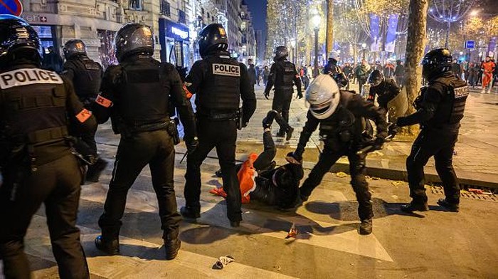 PARIS, FRANCE - DECEMBER 07: Fans clash with police as Moroccan supporters celebrate victory as Morocco qualified for 2022 FIFA World Cup quarterfinals after beating Spain on penalties during the FIFA World Cup Qatar 2022 Round of 16 match between Morocco and Spain at Champs Elysees in Paris, France on December 07, 2022. (Photo by Julien Mattia/Anadolu Agency via Getty Images)