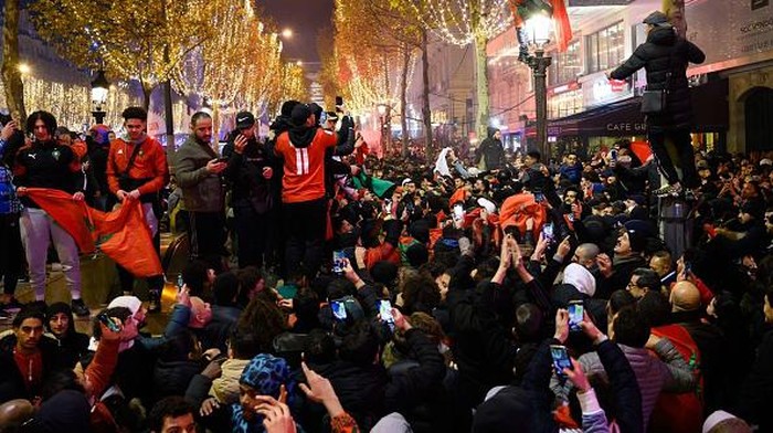 PARIS, FRANCE - DECEMBER 07: Fans clash with police as Moroccan supporters celebrate victory as Morocco qualified for 2022 FIFA World Cup quarterfinals after beating Spain on penalties during the FIFA World Cup Qatar 2022 Round of 16 match between Morocco and Spain at Champs Elysees in Paris, France on December 07, 2022. (Photo by Julien Mattia/Anadolu Agency via Getty Images)