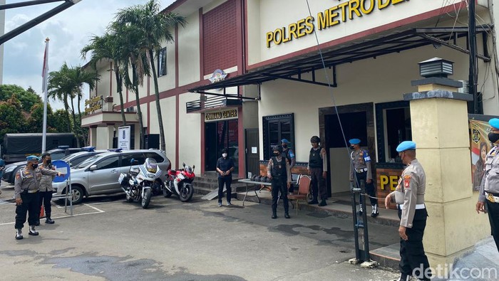 Polisi bersenjata laras panjang siaga di pintu masuk Polres Metro Depok antisipasi bom.
