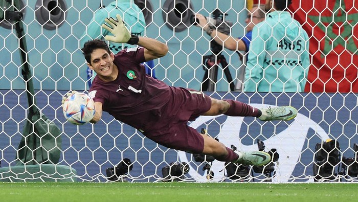 TOPSHOT - Moroccos goalkeeper #01 Yassine Bounou deflects a penalty kick from Spains midfielder #05 Sergio Busquets during the Qatar 2022 World Cup round of 16 football match between Morocco and Spain at the Education City Stadium in Al-Rayyan, west of Doha on December 6, 2022. (Photo by JACK GUEZ / AFP) (Photo by JACK GUEZ/AFP via Getty Images)