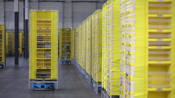 Robot khusus Amazon dapat mengangkut beban berat. Tampak di sini di salah satu gudang Amazon, robot bernama Hercules itu memindahkan rak barang. Foto: Getty Images