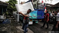 Satu per satu perlengkapan dekorasi diturunkan dari truk.  
