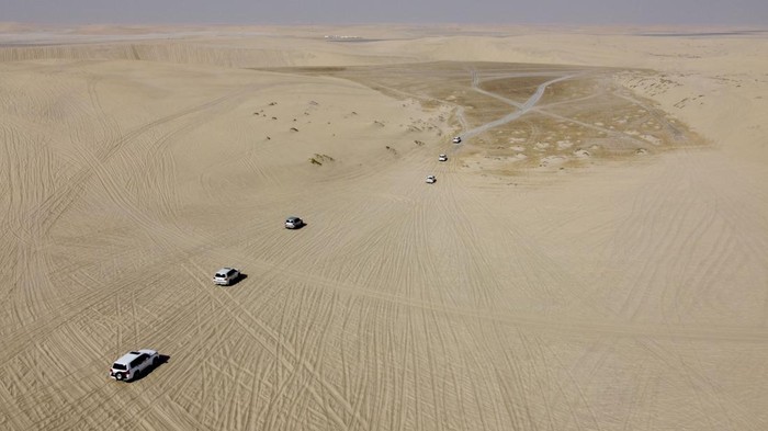 7 Wisata di Doha yang Bisa Dijajal Selain Nonton Piala Dunia DOHA, QATAR - DECEMBER 05: An aerial view of desert as tourists, coming to follow FIFA World Cup 2022 matches, ride camels and use 4X4 vehicles to do Doha Desert Safari in Sealine where 50 kilometers away from the capital city, in Doha, Qatar on December 05, 2022. The safari is one of the favorite activities of those who come to Qatar for the FIFA World Cup 2022. (Photo by Ercin Erturk/Anadolu Agency via Getty Images)