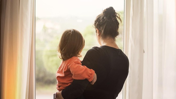 Mother and son looking out of window