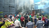 Tampak sejumlah pegawai membantu petugas untuk memadamkan api.