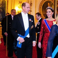 Kate Middleton mengenakan gaun lace warna merah marun rancangan desainer favoritnya, Jenny Packham, untuk menyambut para tamu di Istana Buckingham, London, Inggris, pada Rabu (7/12/2022). Foto: Getty Images