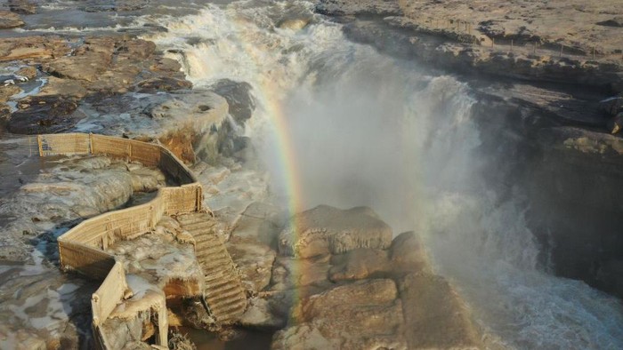 Pesona Pelangi Hiasi Air Terjun Hukou di China Air terjun Hukou ini berada di Sungai Kuning, Shaanxi, China. Saat musim dingin, air terjun ini menyuguhkan pemandangan yang indah yaitu dihiasi oleh pelangi yang cantik.