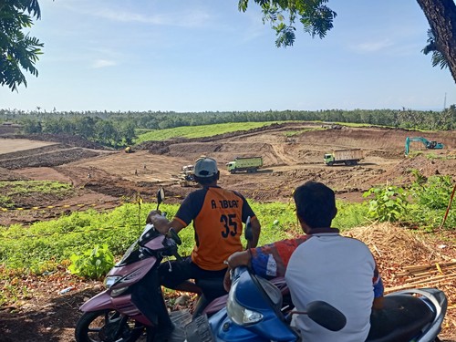 Warga melihat pengerjaan Tol Gilimanuk-Mengwi yang masih dalam tahapan perataan lahan di Banjar Sumbermis, Desa Pekutatan, Kecamatan Pekutatan, Kabupaten Jembrana, Bali, Kamis (8/12/2022).