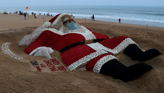 A sand sculpture of Santa Claus is seen on the eastern coast beach of Bay of Bengal at Puri as it is creating by sand artist Sudarshan Pattnaik with the rose for visitors' attraction on the eve of Christmas celebration, 65 km away from the eastern Indian state Odisha's capital city Bhubaneswar. (Photo by STR/NurPhoto via Getty Images)