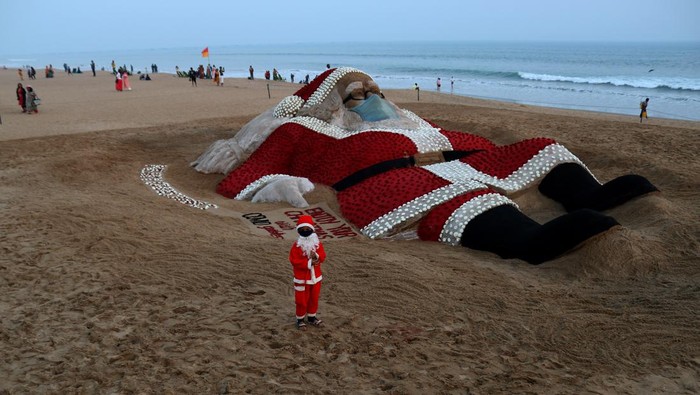 Woah, Ada 'Sinterklas' Raksasa di Pantai India A sand sculpture of Santa Claus is seen on the eastern coast beach of Bay of Bengal at Puri as it is creating by sand artist Sudarshan Pattnaik with the rose for visitors' attraction on the eve of Christmas celebration, 65 km away from the eastern Indian state Odisha's capital city Bhubaneswar. (Photo by STR/NurPhoto via Getty Images)