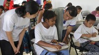Ketua Yayasan English Goes to Kampung, Jenni Rios dan Compliance and Risk Management Director Asuransi Astra, Adi Sepiarso saat melihat anak-anak belajar di learning center.   