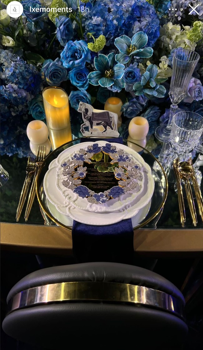 Masing-masing tamu yang hadir duduk di bangu-bangku yang telah disediakan. Bangku-bangku tersebut dilengkapi dengann meja yang sudah didekorasi sedemikian rupa dengan dipenuhi bunga-bunga berwarna ungu dan biru, serta menu dan peralatan makan berwarna keemasan. Foto: Instagram/@lxemoments