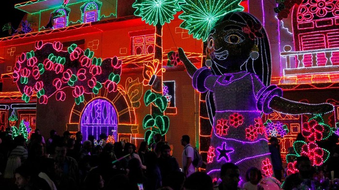 People walk in front of the traditional Christmas lights in Medellin, Colombia, on December 8, 2022. (Photo by Freddy BUILES / AFP) (Photo by FREDDY BUILES/AFP via Getty Images)