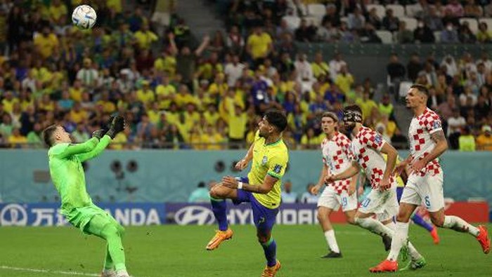 Croatias goalkeeper #01 Dominik Livakovic saves a shot by Brazils midfielder #07 Lucas Paqueta (2ndL) during the Qatar 2022 World Cup quarter-final football match between Croatia and Brazil at Education City Stadium in Al-Rayyan, west of Doha, on December 9, 2022. (Photo by ADRIAN DENNIS / AFP)