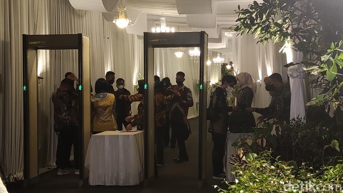 Petugas keamanan memeriksa tamu yang menghadiri acara midodareni di rumah Erina Gudono, Jumat (9/12/2022).