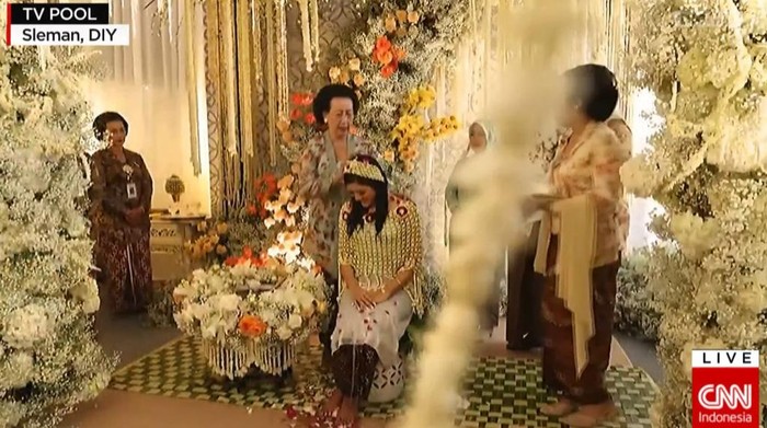 Tujuh wanita memulai prosesi siraman terhadap calon istri Kaesang Pangarep, Erina Gudono. Prosesi ini dilakukan sebagai bentuk pembersihan diri sebelum menikah. (YouTube CNNIndonesia)