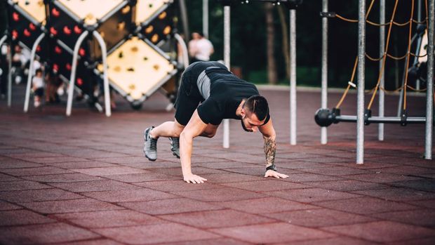fitness details of man doing pushups. sports athlete in park working out
