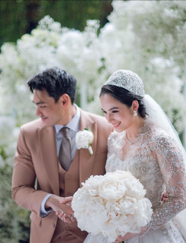 Sementara sang suami, Rob Clinton Kardinal, tampil elegan dengan setelan tuksedo yang dipadu vest, kemeja putih dan dasi satin warna abu-abu. Foto: Instagram/@lxemonents @iluminen