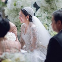 Gaun lengan panjang dengan leher berpotongan V ini tampak mewah berhias payet, mutiara serta kristal. Sekilas, gaun ini mengingatkan pada busana pengantin Grace Kelly dan Kate Middleton. Foto: Instagram/@lxemonents @iluminen