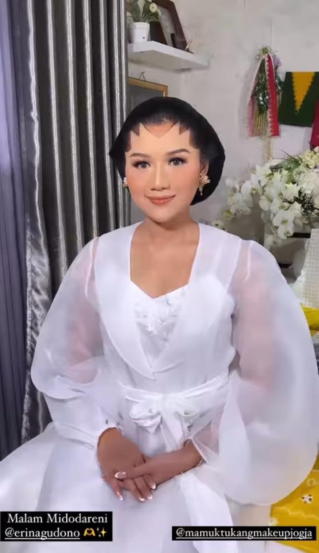 Erina Gudono mempercayakan Bennu Sorumba untuk memoles wajahnya di malam midodareni. Dalam unggahan Instagram sang makeup artist, Erina tersenyum saat memperlihatkan riasan flawless di wajahnya dalam balutan robe putih transparan. Foto: dok. Instagram @bennusorumba